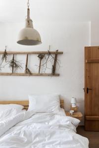 上陶恩Sloho Bergurlaub的一间卧室配有一张带白色床单和一盏灯的床。