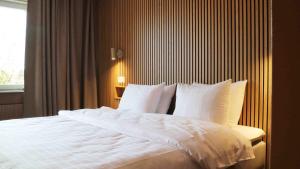 谢莱夫特奥迈德雷富商务酒店的一间卧室配有一张带白色床单的床和一扇窗户。