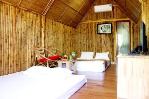 槟知Coco Island Cồn Phụng的客房设有两张床和一张带电视的桌子。