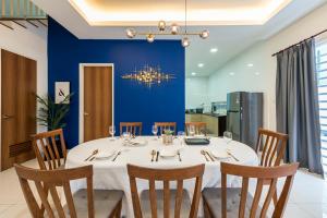 芙蓉5Bedroom Villa @ Seremban 20pax Netflix Projector Pool的一间设有白色桌子和蓝色墙壁的用餐室