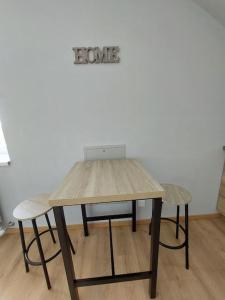索恩河畔沙隆Famille House 202的一张带两把椅子的木桌和一个读爱的标语