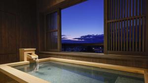 加贺吉田雅三诺卡旅馆的一个带窗户的游泳池,享有城市美景