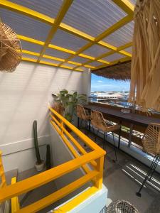 马尼拉Rain Airport Bed and Breakfast的一间设有桌子和黄色栏杆的用餐室