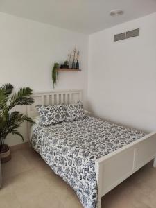 圣罗克Estudio Puerto de Sotogrande的白色房间的床,床罩和植物
