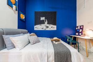 芙蓉5Bedroom Villa @ Seremban 20pax Netflix Projector Pool的一间卧室配有一张蓝色墙壁的床