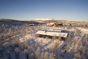 耶卢Nydelig og Moderne hytte på Kikut Geilo - 6 senger, 4 soverom og jacuzzi的雪中房屋的空中景观