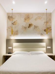 罗马花团锦簇酒店的卧室配有白色的床和鲜花墙