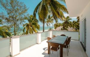 吉汶瓦Imani Penthouse - Private Beachfront apartment with Spectacular Ocean Views的一个带桌椅的海景阳台