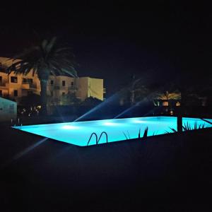 圣西普里安Les Capitelles : Appartement vue montagne en residence avec piscine -sur le front de mer的一座晚上拥有蓝色灯光的大型游泳池