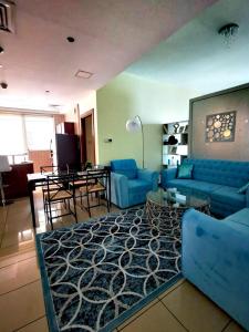 迪拜Serenity Paradise 2BR in Marina的客厅配有蓝色的沙发和桌子