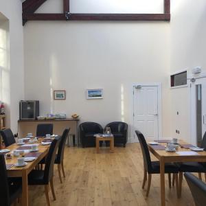 坎贝尔城Grammar Lodge Guest House的用餐室配有木桌和椅子