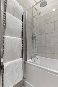 廷茅斯Seabreeze的浴室配有白色毛巾和浴缸。