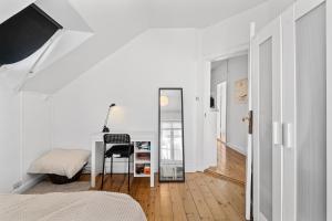 哥本哈根Rooms in quiet white villa apartment Hortensiavej 8 on Frederiksberg C的白色卧室配有书桌和镜子