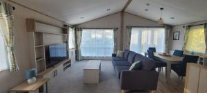托基Luxury Lodge @ Hoburne Devon Bay的客厅配有蓝色的沙发和电视