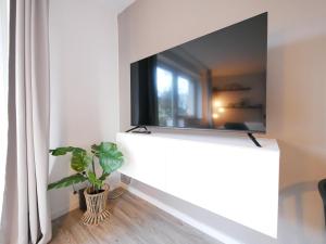 奥斯纳布吕克75 m2, zentral, Küche, Balkon, Parkplatz的客厅里墙上的电视机,有植物
