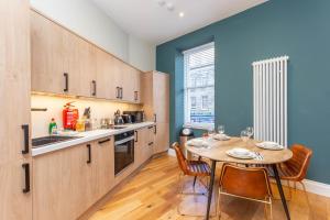 爱丁堡Royal 2bed apartment City Center的一间带桌椅的厨房和一间带蓝色墙壁的厨房
