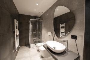 都灵San Carlo Suite Torino的一间带水槽、卫生间和镜子的浴室