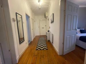 格拉斯哥Irongray House的走廊上设有一张床和地毯的房间