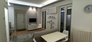 米兰Luxury House Lupetta 3的带沙发、桌子和时钟的客厅