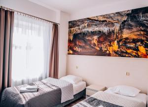 斯托尼拉斯奇Hotel Stronie的一间卧室设有两张床,墙上挂着一幅画