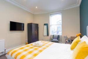 爱丁堡Royal 2bed apartment City Center的卧室配有一张床,墙上配有电视。