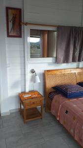 圣罗斯Nouveau logement T2 avec vue sur mer et montagne的一间卧室配有一张床和一张带台灯的桌子