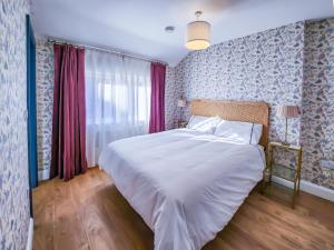 金塞尔The Kinsale 4 Center的卧室配有白色床和蓝色粉色壁纸