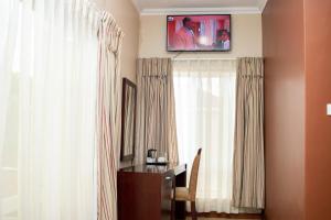 布兰太尔Krisstar Lodge的一间设有一张桌子和一台墙上的电视的房间