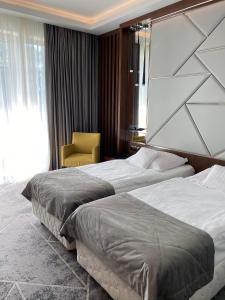 露米雅Hotel Falko的酒店客房,配有两张床和椅子