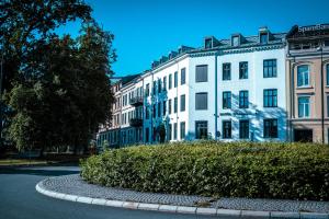 奥斯陆Hotel Filip的一座白色的大建筑,前面有灌木丛
