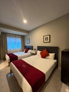 巴东马士力Perdana Serviced Apartment & Resorts的酒店客房设有两张床和窗户。
