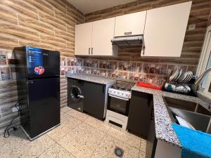 科纳克里SMB-gn RÉSIDENCE LAMBANDJI的厨房配有黑色冰箱和洗碗机。