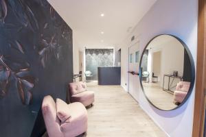 都灵San Carlo Suite Torino的走廊设有粉红色的椅子和镜子