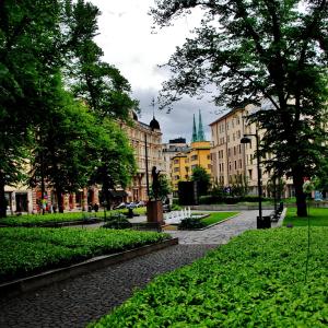 赫尔辛基戴安娜公园旅舍的一条有建筑的城市街道和一个树木繁茂的公园