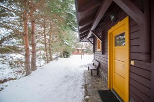 利普托斯基米库拉斯Holiday Home Tatralandia的雪中建筑物一侧的黄色门