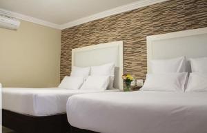 派恩敦Bayside Hotel Pinetown的两张睡床彼此相邻,位于一个房间里