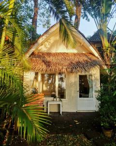 象岛Saffron On The Sea Resort的小屋设有茅草屋顶和白色门