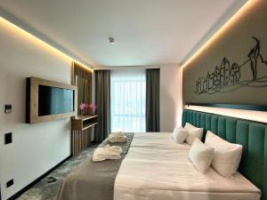 比得哥什Focus Hotel Premium Bydgoszcz的配有一张床和一台平面电视的酒店客房