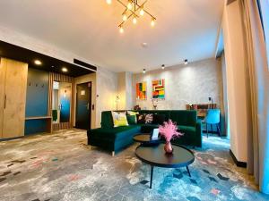比得哥什Focus Hotel Premium Bydgoszcz的客厅配有绿色沙发和桌子