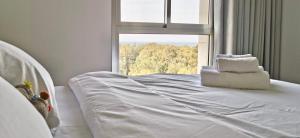 纳哈里亚Sea view apartment with Jacuzzi near beach的窗户客房内的一张白色床