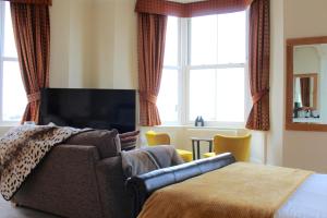 莫克姆皇冠酒店的一间带沙发、电视和床的卧室