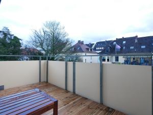 奥斯纳布吕克75 m2, zentral, Küche, Balkon, Parkplatz的阳台设有白色的围栏和木板凳。
