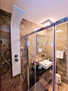 拉纳卡Sveltos Residence Suites的带淋浴、盥洗盆和淋浴的浴室