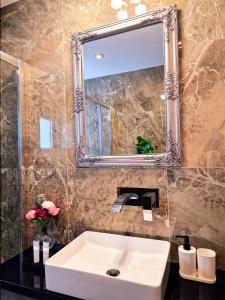 拉纳卡Sveltos Residence Suites的浴室设有白色水槽和镜子