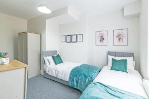 普雷斯科特Luxury 5 Bedroom Holiday Home Within Prescot的一间卧室配有两张绿色和白色的床