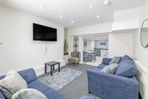 普雷斯科特Luxury 5 Bedroom Holiday Home Within Prescot的客厅配有蓝色的沙发和电视