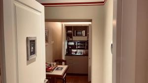 的里雅斯特乐6A住宅酒店的走廊通往带桌子和微波炉的厨房