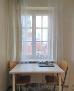 波兹南Rynek 9的窗户前的白色桌子和椅子