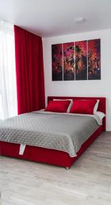 基辅MYFREEDOM Апартаменти метро Нивки的一间卧室配有一张带红色窗帘的大床