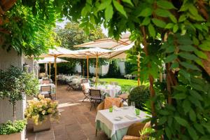 萨尔茨堡嘎斯霍夫布朗德斯塔特酒店的花园内带桌子和遮阳伞的庭院